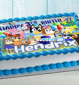Colorful puppy-themed edible cake topper on a kids birthday cake with blue frosting