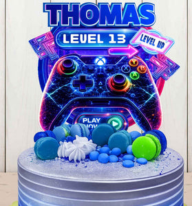 Personalized gaming birthday cake topper with name Thomas and Level 13, neon game controller design on blue birthday cake