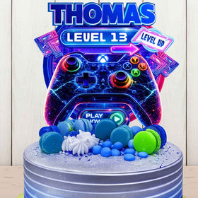 Personalized gaming birthday cake topper with name Thomas and Level 13, neon game controller design on blue birthday cake
