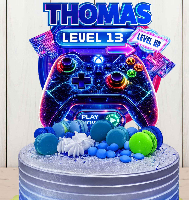 Personalized gaming birthday cake topper with name Thomas and Level 13, neon game controller design on blue birthday cake