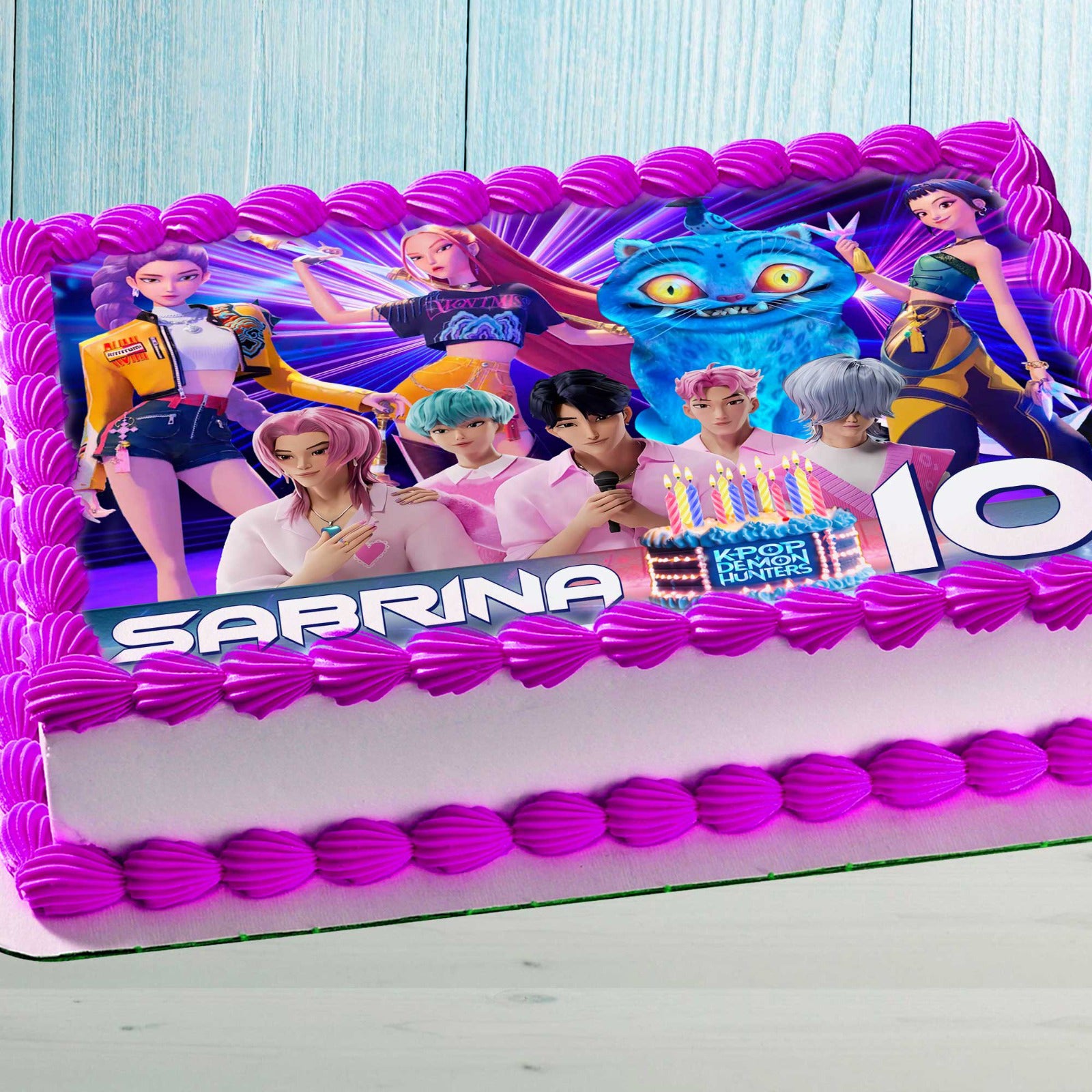 Anime-style K-Pop characters edible cake topper on a pink decorated kids birthday cake