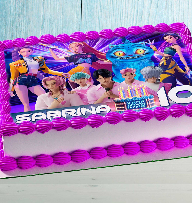 Anime-style K-Pop characters edible cake topper on a pink decorated kids birthday cake