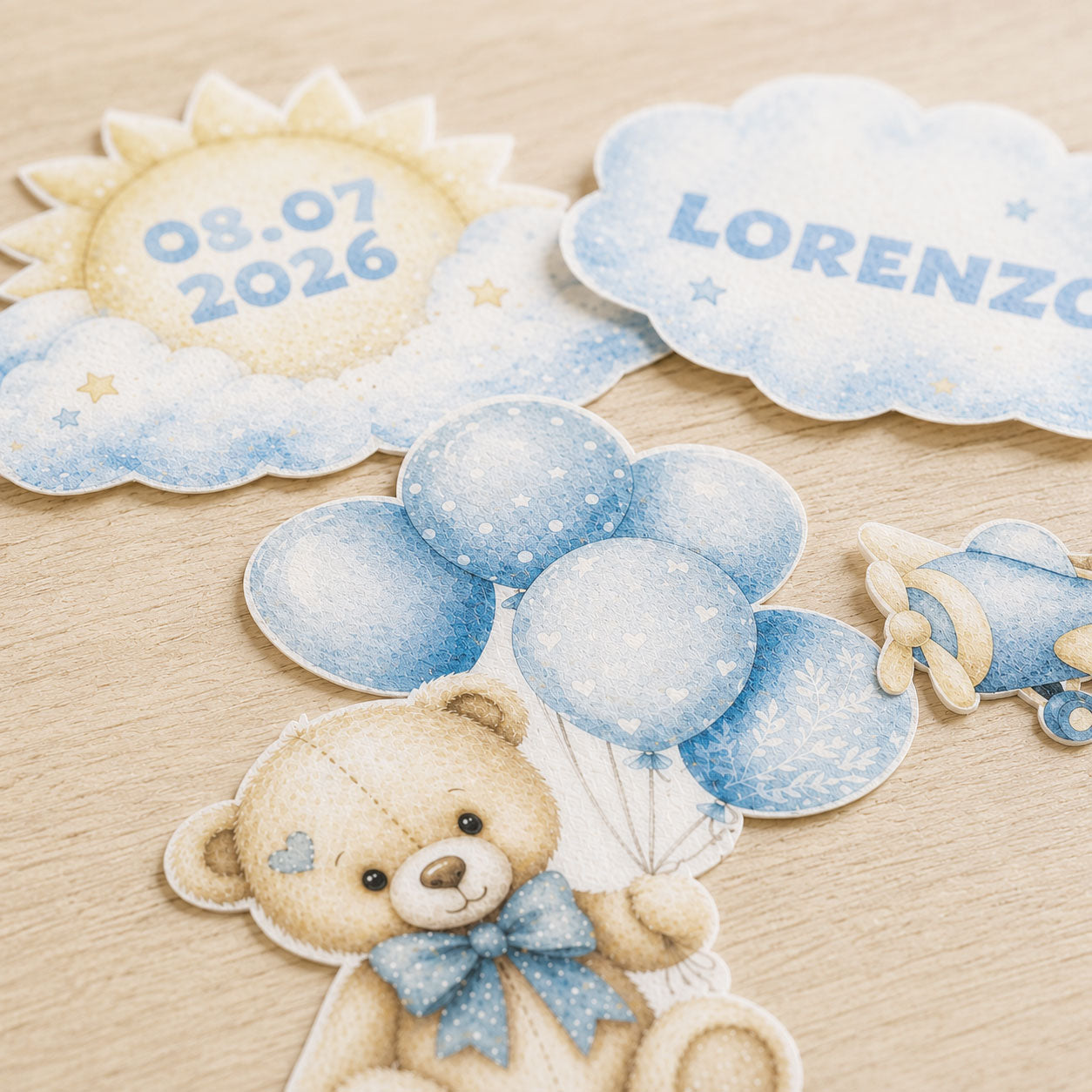 Close-up of teddy bear travel edible cake topper pieces with soft blue watercolor details