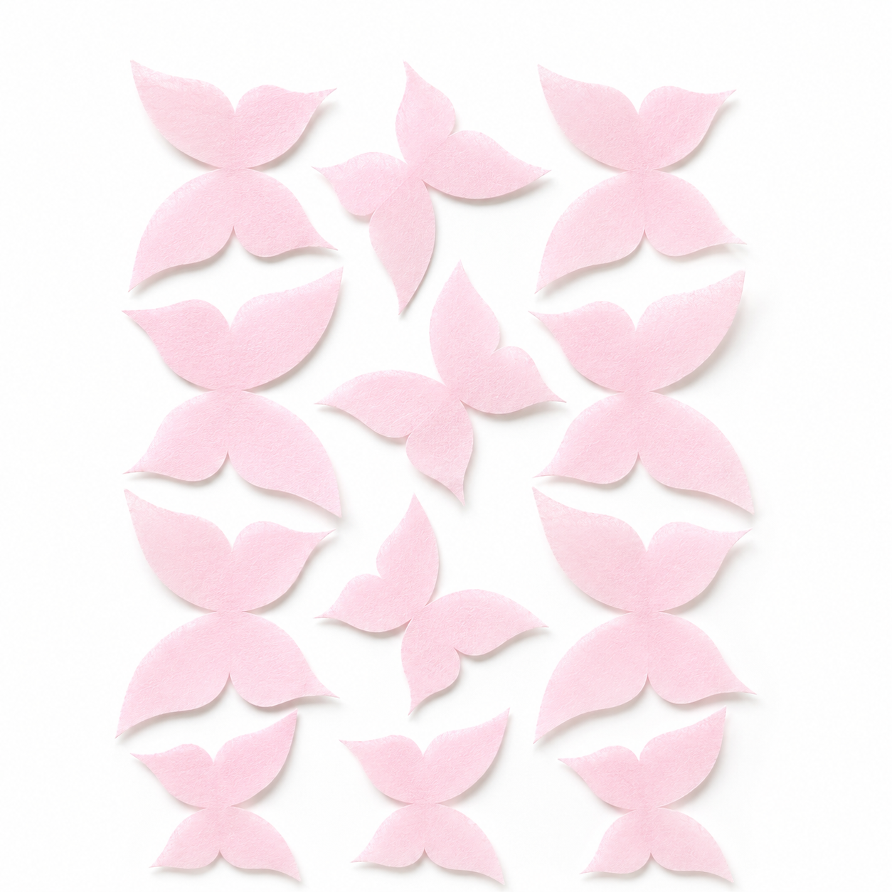 Flat lay of 12 pink wafer paper butterflies in three sizes arranged on a white background, what you receive