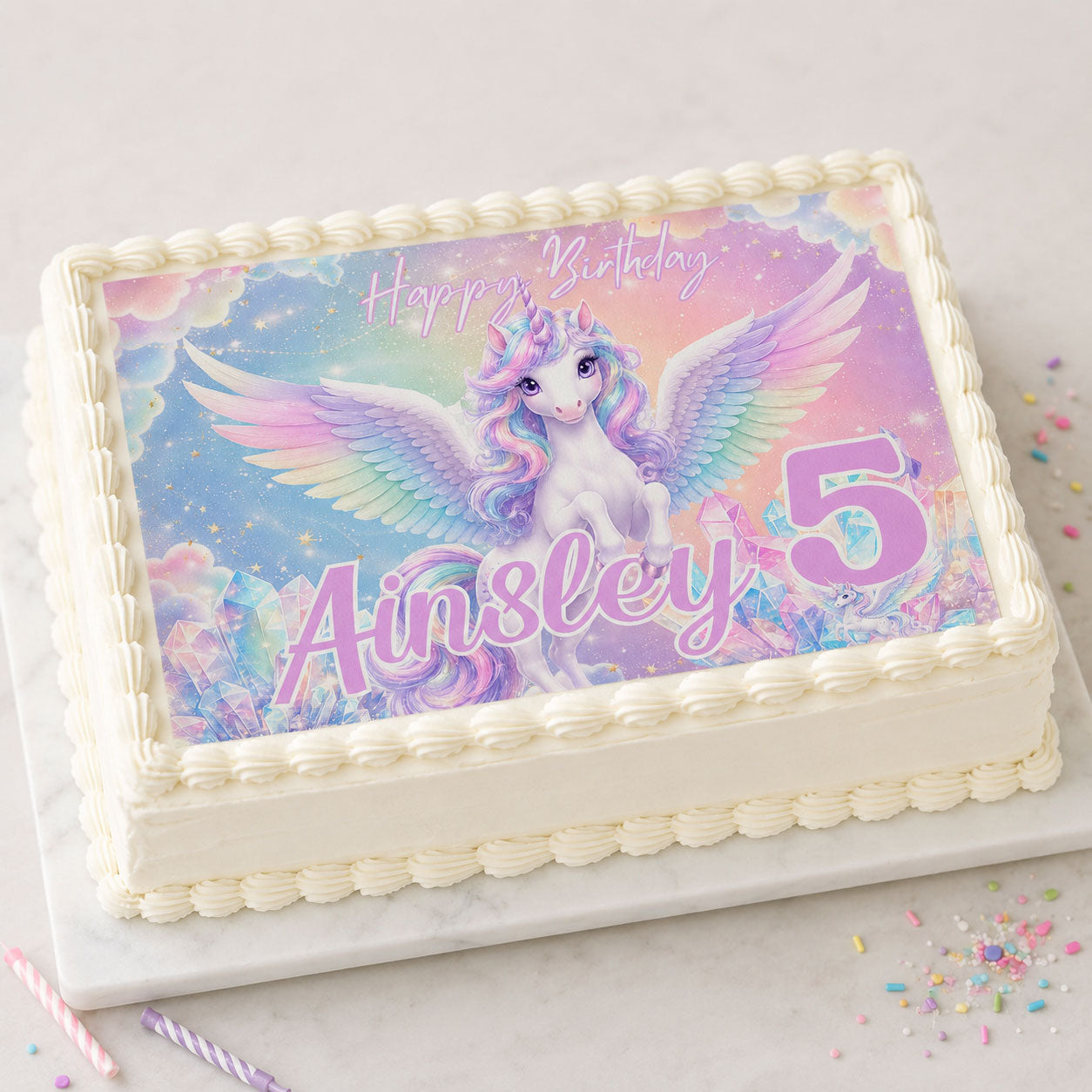 Unicorn birthday edible cake topper personalized with name and age on a rectangular cake