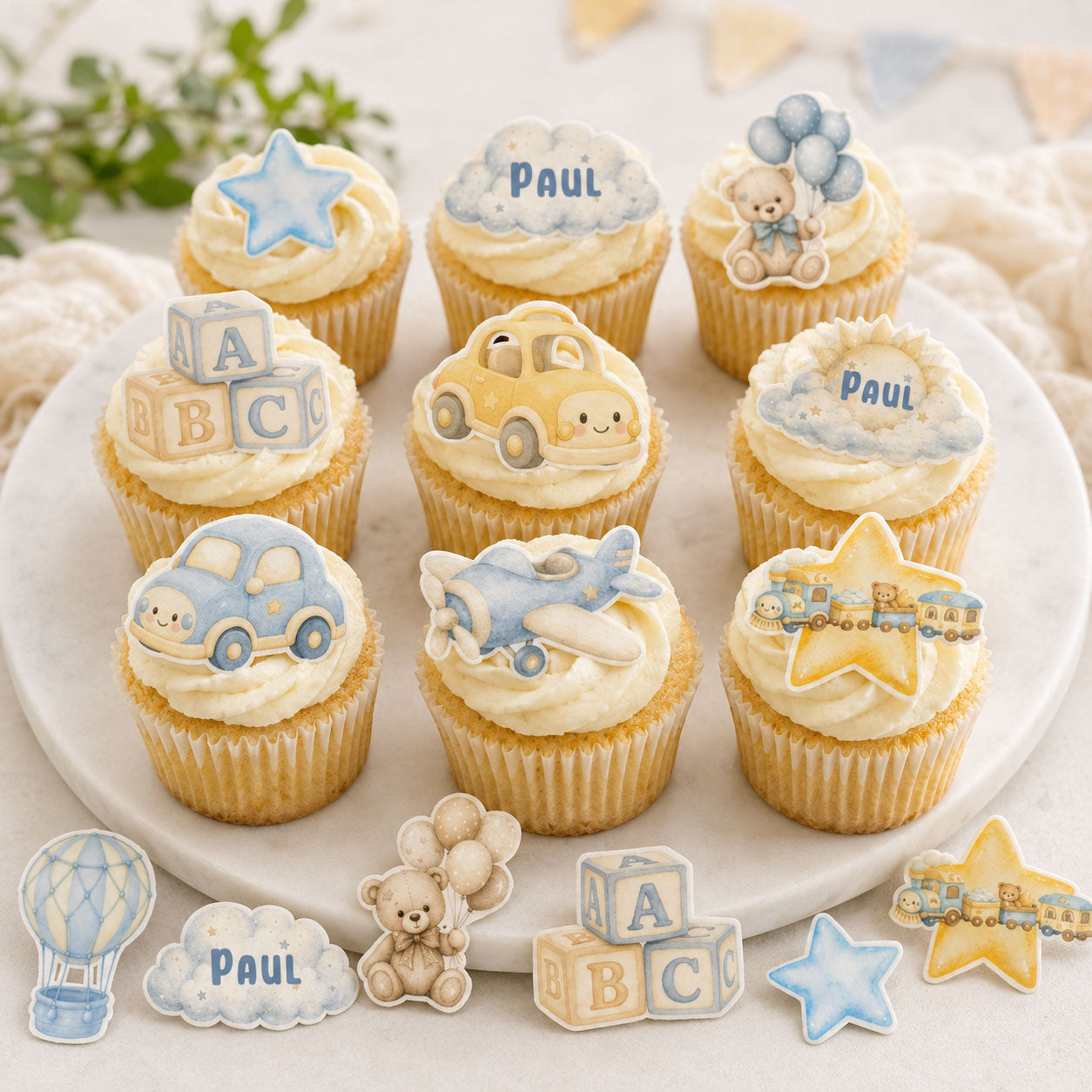 Baby boy edible cupcake toppers displayed on frosted cupcakes for a birthday party