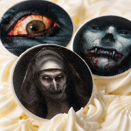 Close-up of horror movie edible cake toppers on frosted cupcakes showing detailed fan art illustrations