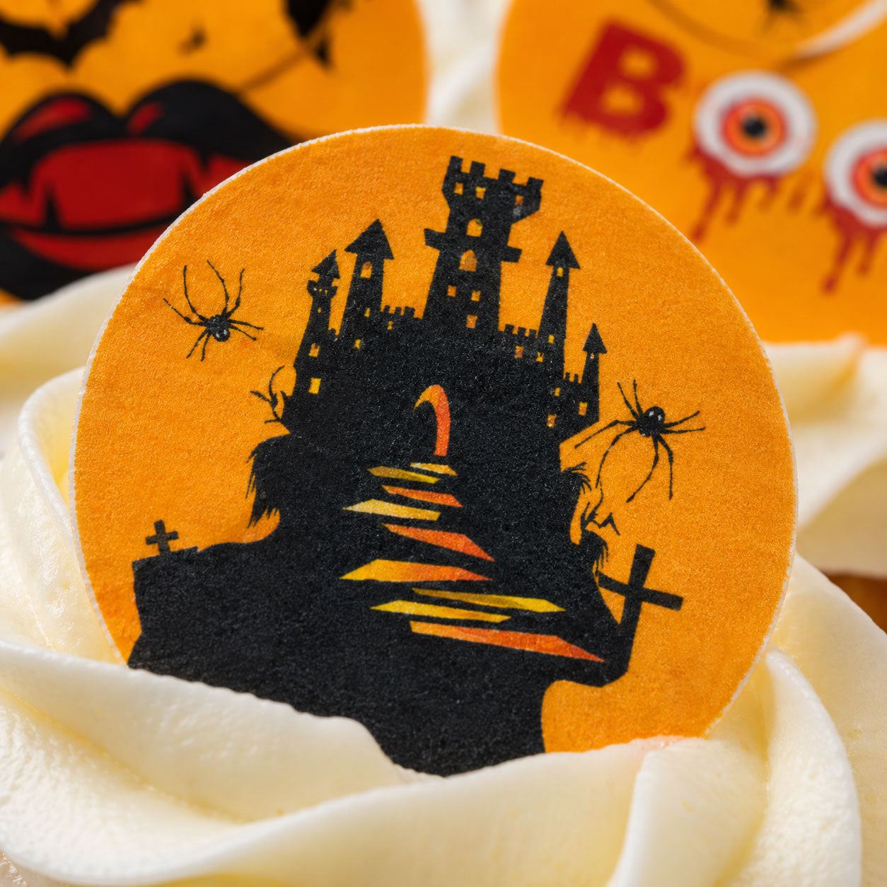 Close-up of graveyard Halloween edible topper showing haunted castle design detail on a cupcake