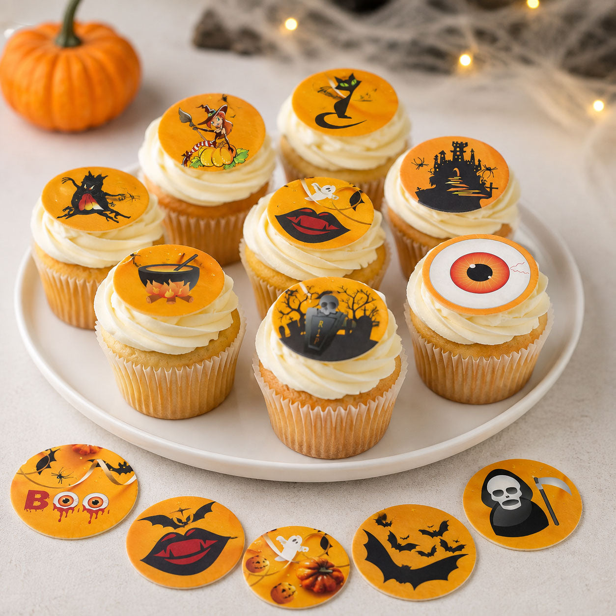 Graveyard Halloween edible cupcake toppers arranged on a plate of frosted cupcakes